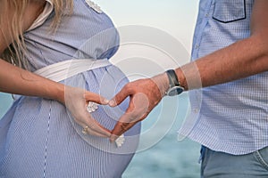 Pregnant woman.ÃÂ Couple holding hands in a heart.